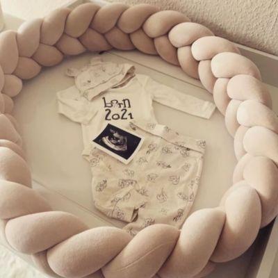 Contour de lit bébé beige en velours, décoration douce pour chambre nouveau-né.
