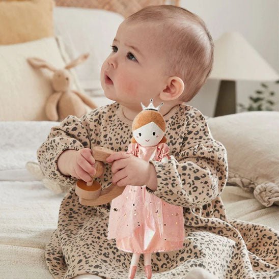 un bébé qui joue avec son doudou bébé en regardant vers le haut