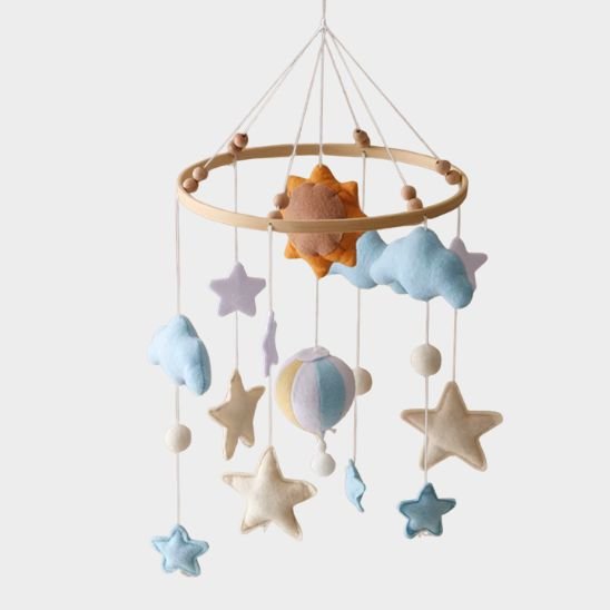 Mobile musical bébé en feutrine suspendu au-dessus du berceau, étoiles et nuages