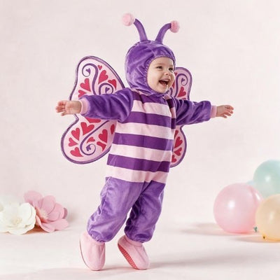 Bébé qui rit, bras ouverts, en déguisement papillon mauve avec ailes à cœurs