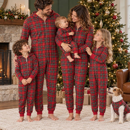 Famille et chien en combinaison pyjama Noël famille à carreaux rouge devant le sapin et la cheminée