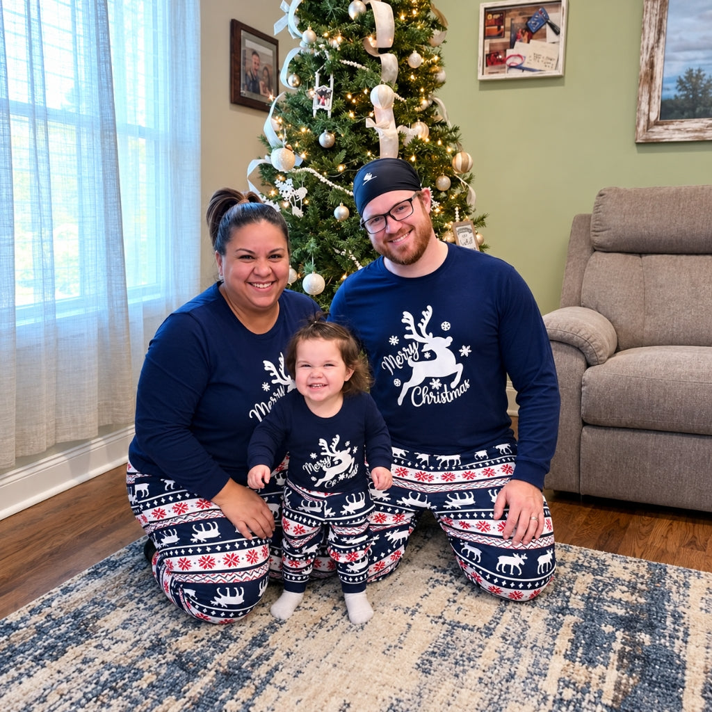 Famille en pyjama Noël famille bleu marine Comète au renne Merry Christmas devant le sapin