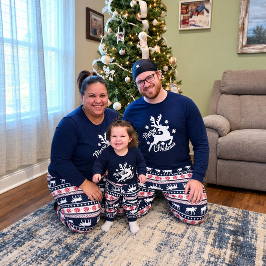 Famille en pyjama Noël famille bleu marine Comète au renne Merry Christmas devant le sapin