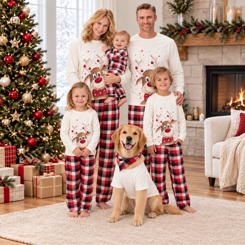 Famille avec bébé et chien en pyjama Noël famille renne Grelot devant le sapin