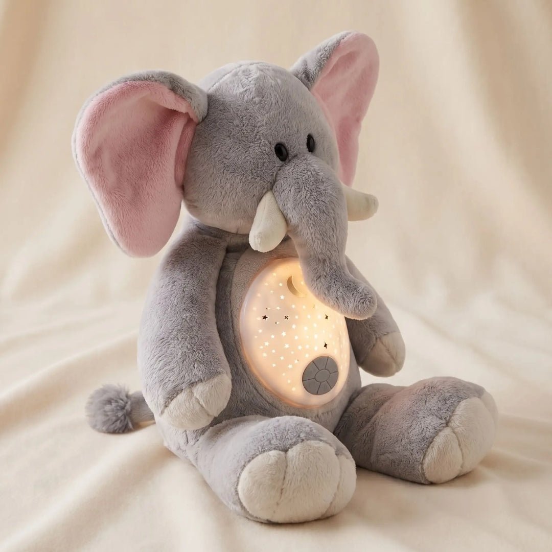 Peluche éléphant Pompon avec son dôme projecteur allumé sur un drap crème
