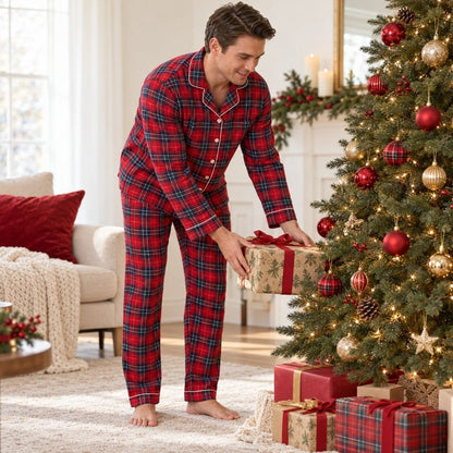 Papa en pyjama de Noël écossais tartan rouge déposant un cadeau sous le sapin