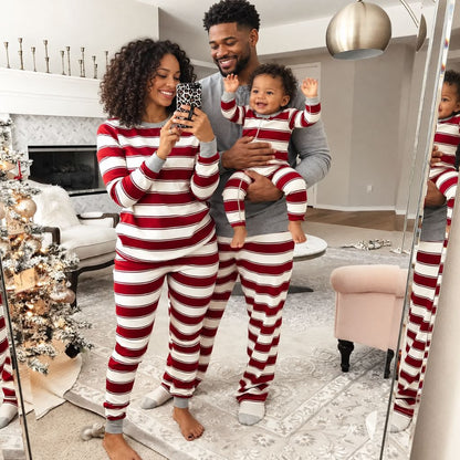 Maman, papa et bébé en pyjama Noël famille rayé Marinière devant le miroir