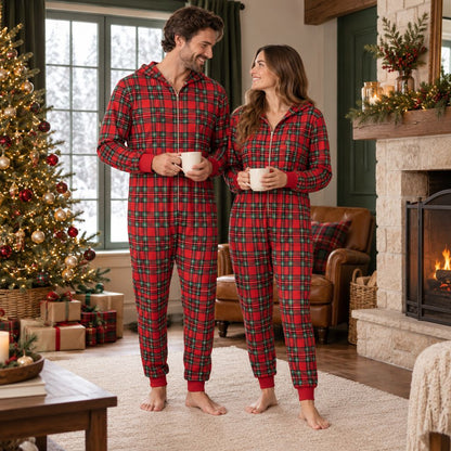 Couple en combinaison pyjama de Noël à carreaux avec une tasse de chocolat chaud
