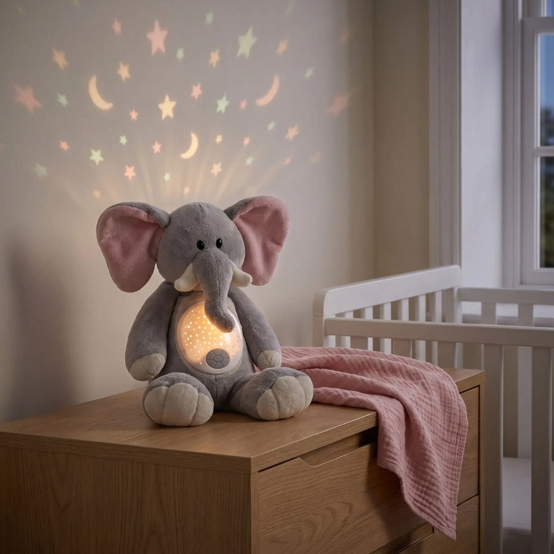 Peluche éléphant veilleuse Pompon sur une commode, étoiles et lunes projetées au mur