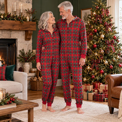 Grands-parents en combinaison pyjama Noël famille tartan rouge devant le sapin