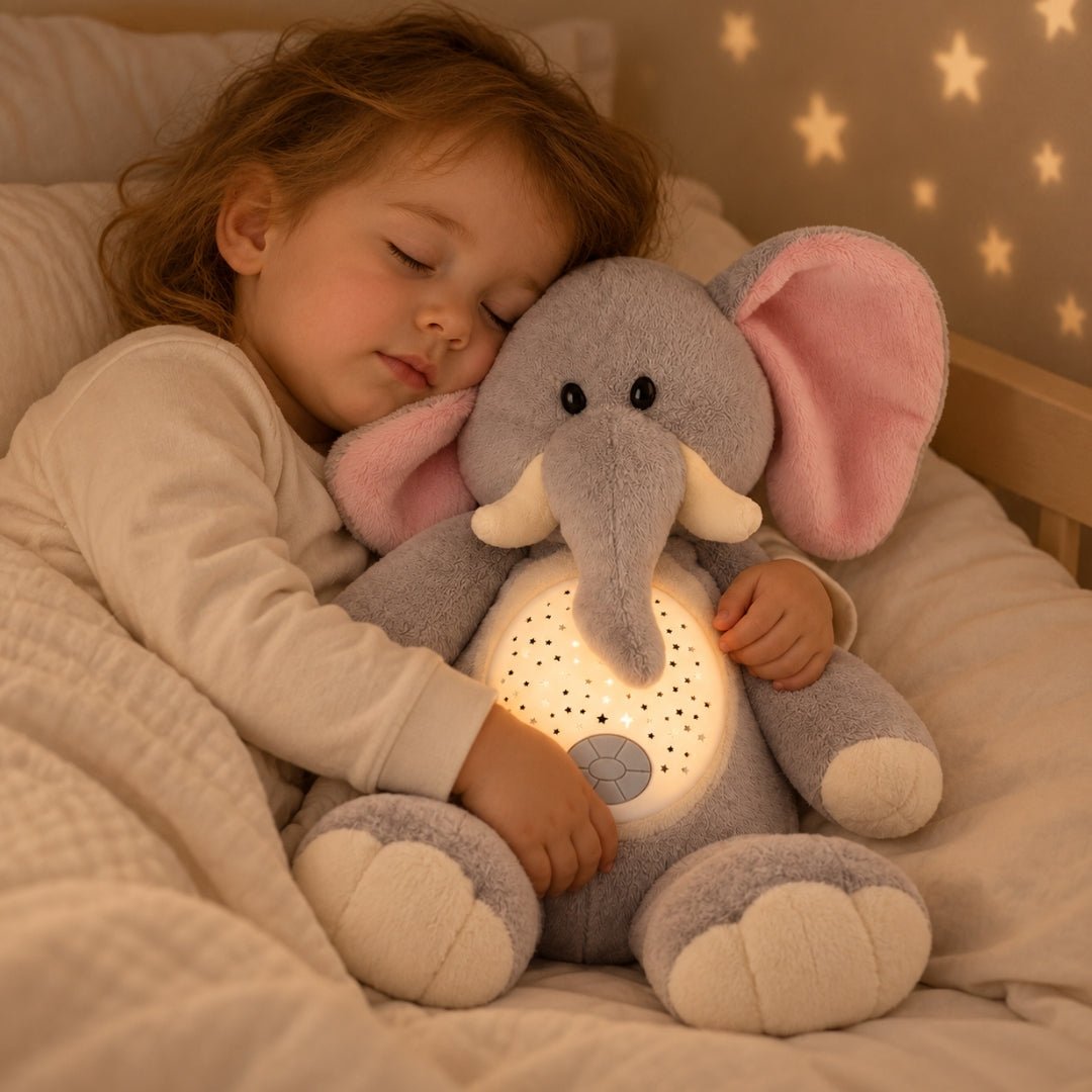 Fillette endormie qui serre sa peluche éléphant veilleuse Pompon dans son lit