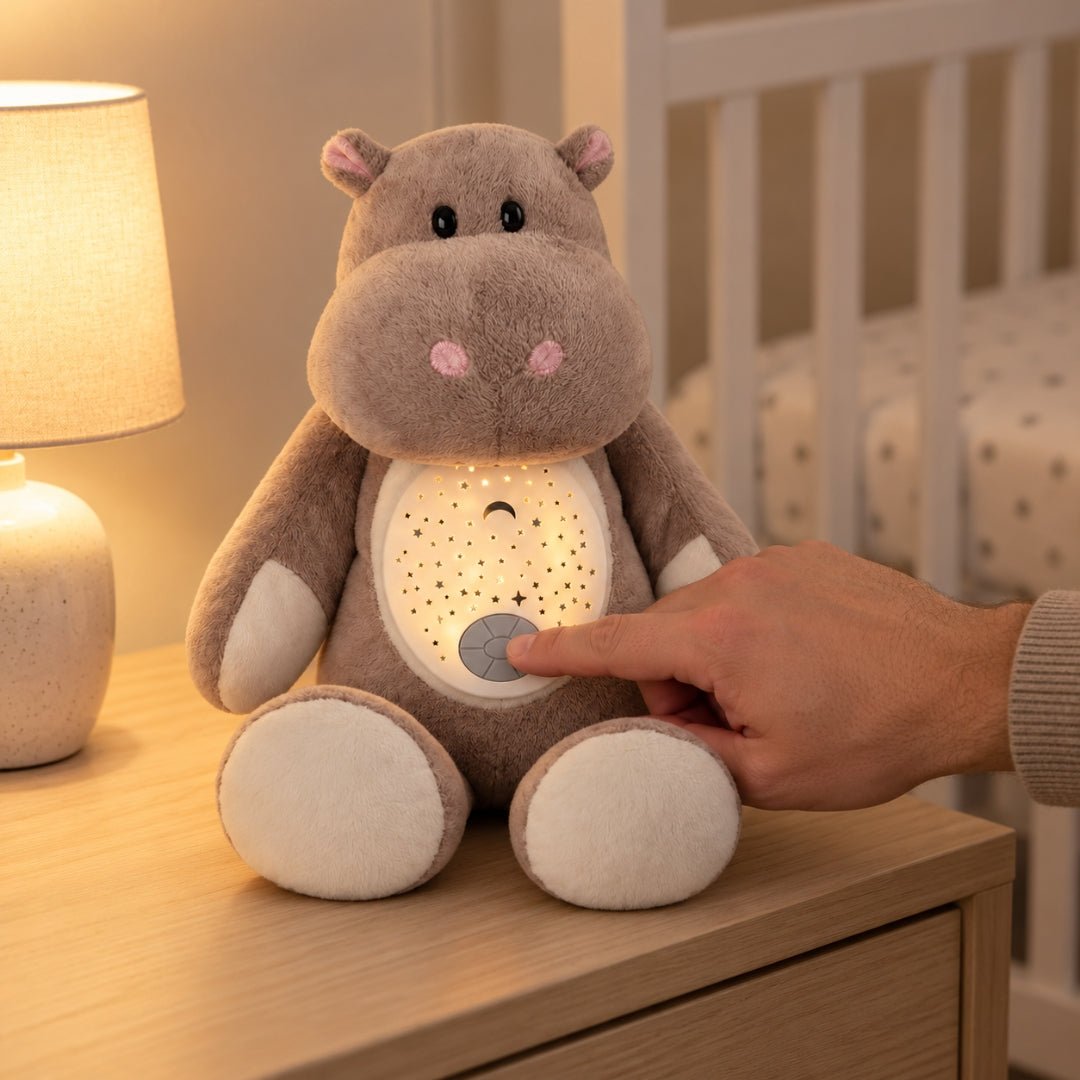 Main qui appuie sur le bouton de la peluche hippopotame Hippolyte pour allumer les étoiles