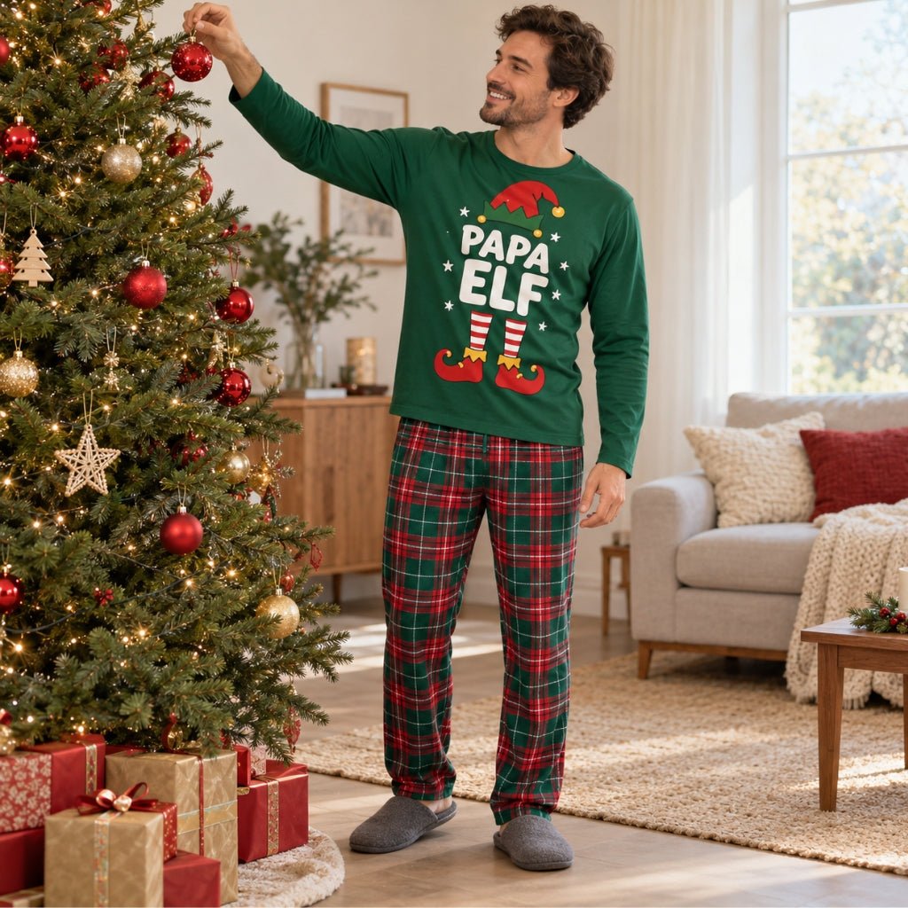 Papa en pyjama de Noël Papa Elf accrochant une boule au sapin