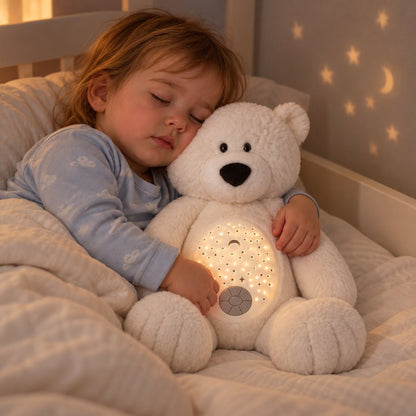 Enfant endormi qui serre sa veilleuse ours polaire Flocon dans son lit