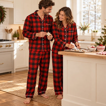 Couple en pyjama de Noël écossais rouge et noir décorant des biscuits