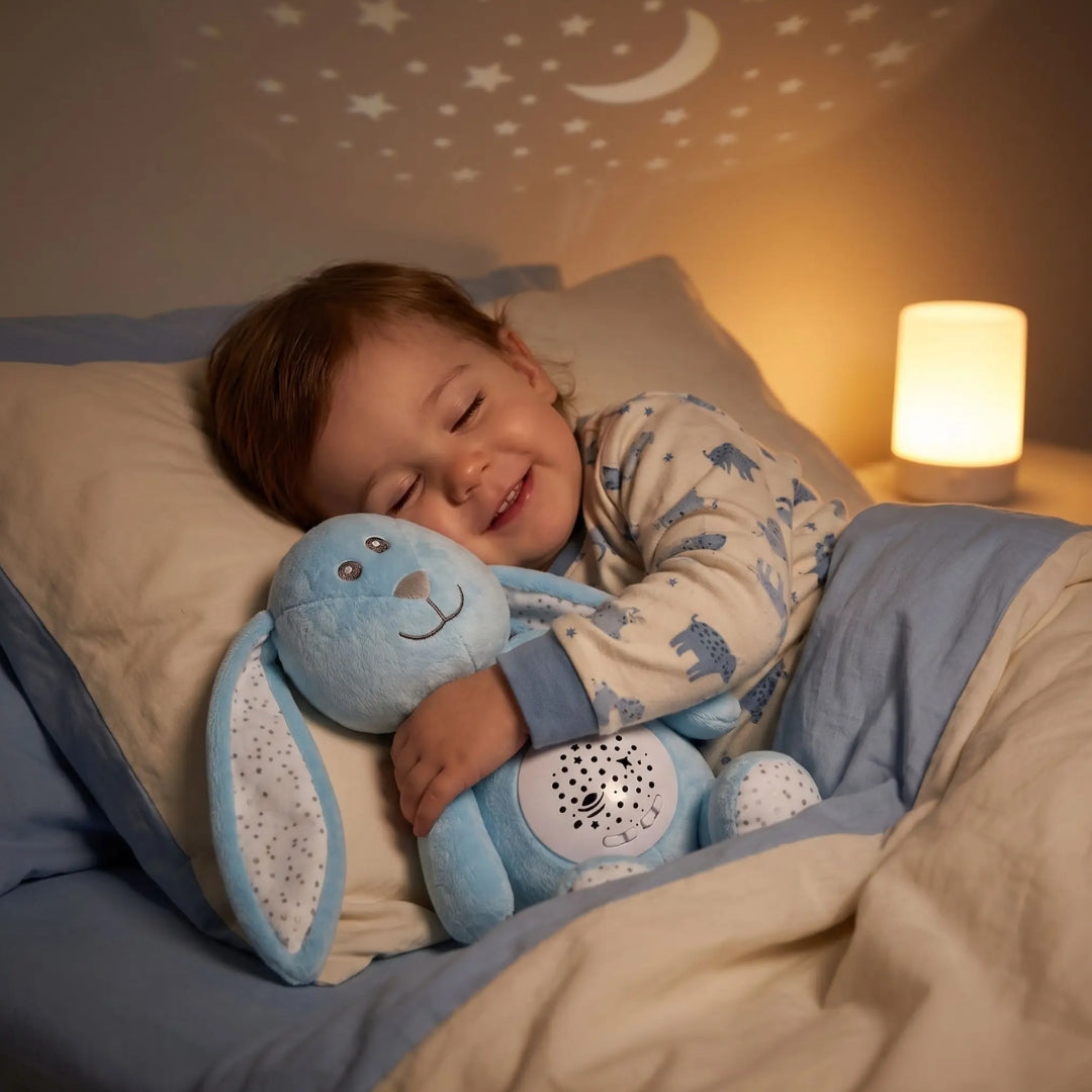 Enfant endormi qui serre son doudou veilleuse Lulune sous un ciel d'étoiles
