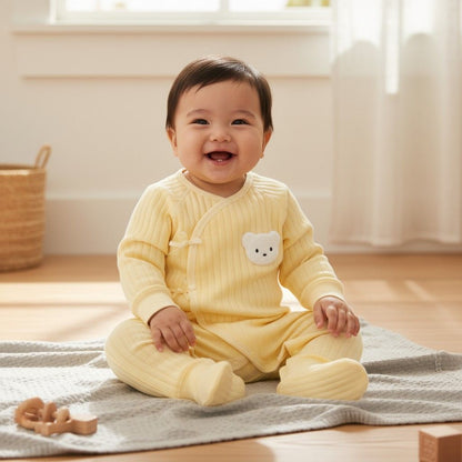 Détail de la tête d’ourson brodée sur la barboteuse bébé unisexe jaune