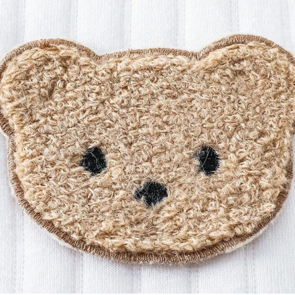 Détail des liens noués de la barboteuse bébé unisexe beige doux