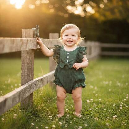 Barboteuse fille combinaison estivale vert dentelle noeud bébé debout prairie clôture bois