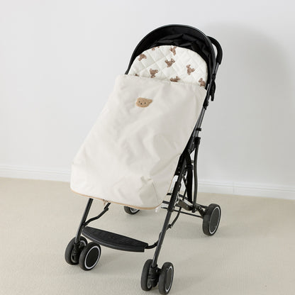 Chancelière crème installée sur une poussette canne