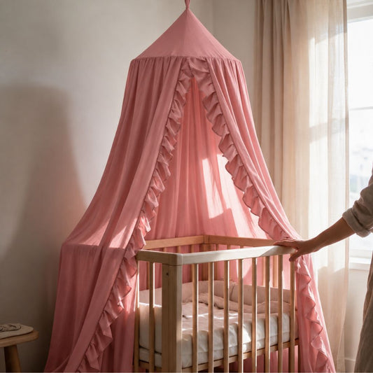 Ciel de lit à volants Froufrou vieux rose suspendu au-dessus d'un berceau en bois