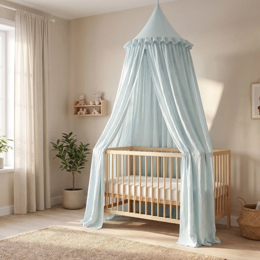 Ciel de lit bébé en gaze de coton bleu clair au-dessus d'un lit bébé
