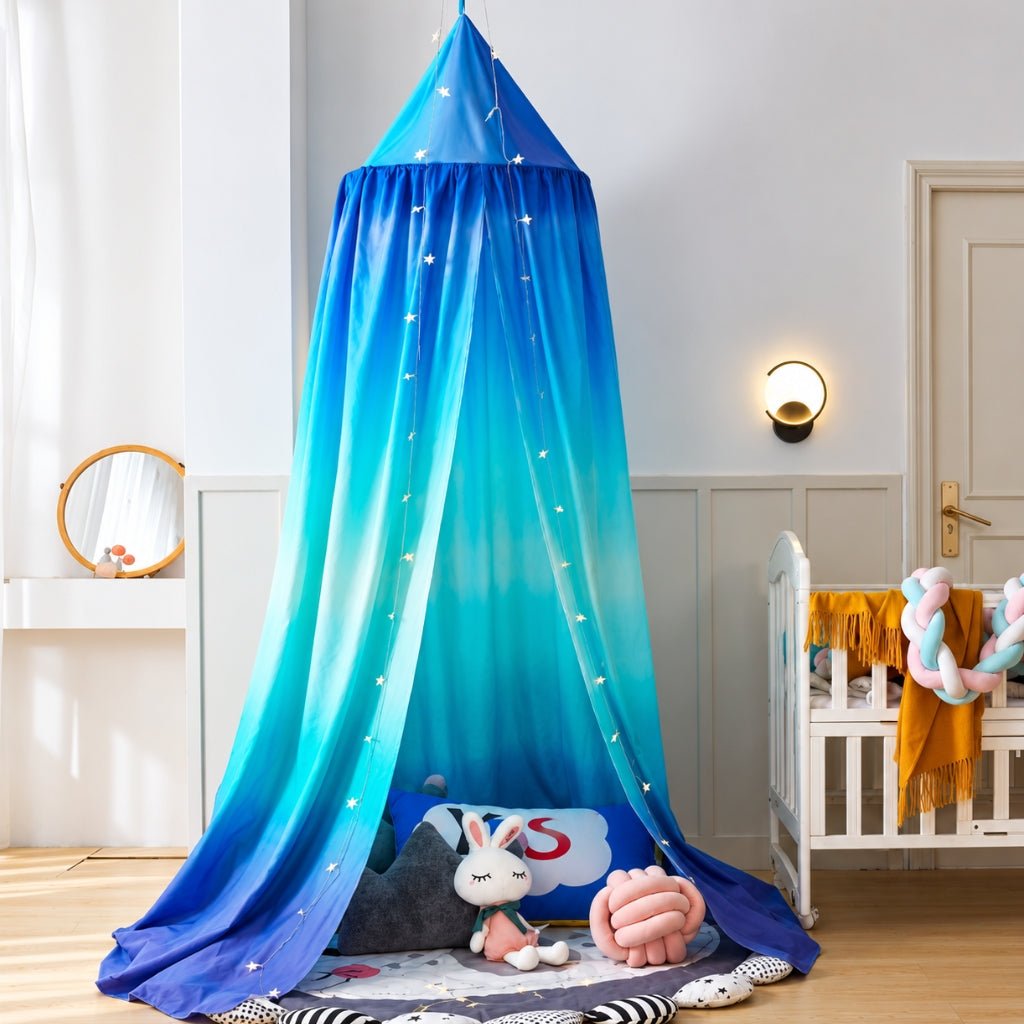 Ciel de lit en dégradé bleu installé en coin jeu avec coussins et peluches
