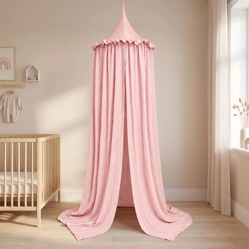 Ciel de lit en gaze de coton rose installé au sol comme une petite tente