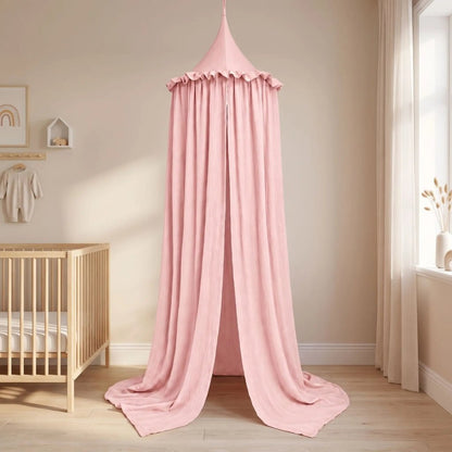 Ciel de lit en gaze de coton rose installé au sol comme une petite tente