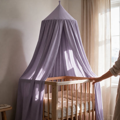 Ciel de lit pour bébé fille couleur lilas dans une chambre lumineuse