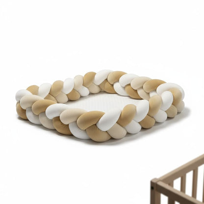 Coussin tressé en velours 3 couleurs servant de contour de lit bébé.