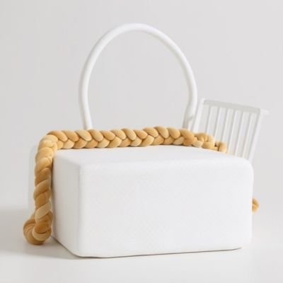 Contour de lit bébé camel en velours doux posé sur un matelas blanc