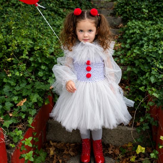 Costume clown enfant fille en extérieur avec bottes rouges et ballon