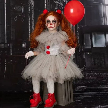 Fillette en costume clown enfant assise sur une caisse en bois, ballon rouge