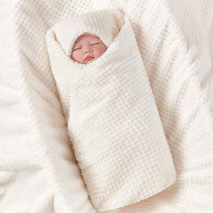 Enfant blotti dans une couverture bébé blanche douce et moelleuse