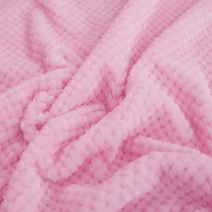 Bébé dormant paisiblement sous une couverture bébé rose
