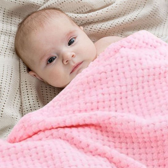 Enfant apaisé sous une couverture bébé rose pastel réconfortante