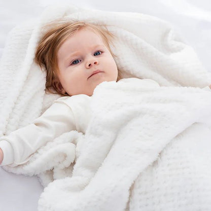 Bébé endormi sous une couverture bébé blanche cocooning
