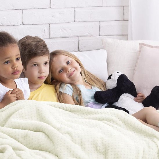 Enfant jouant sur une couverture bébé blanche confortable