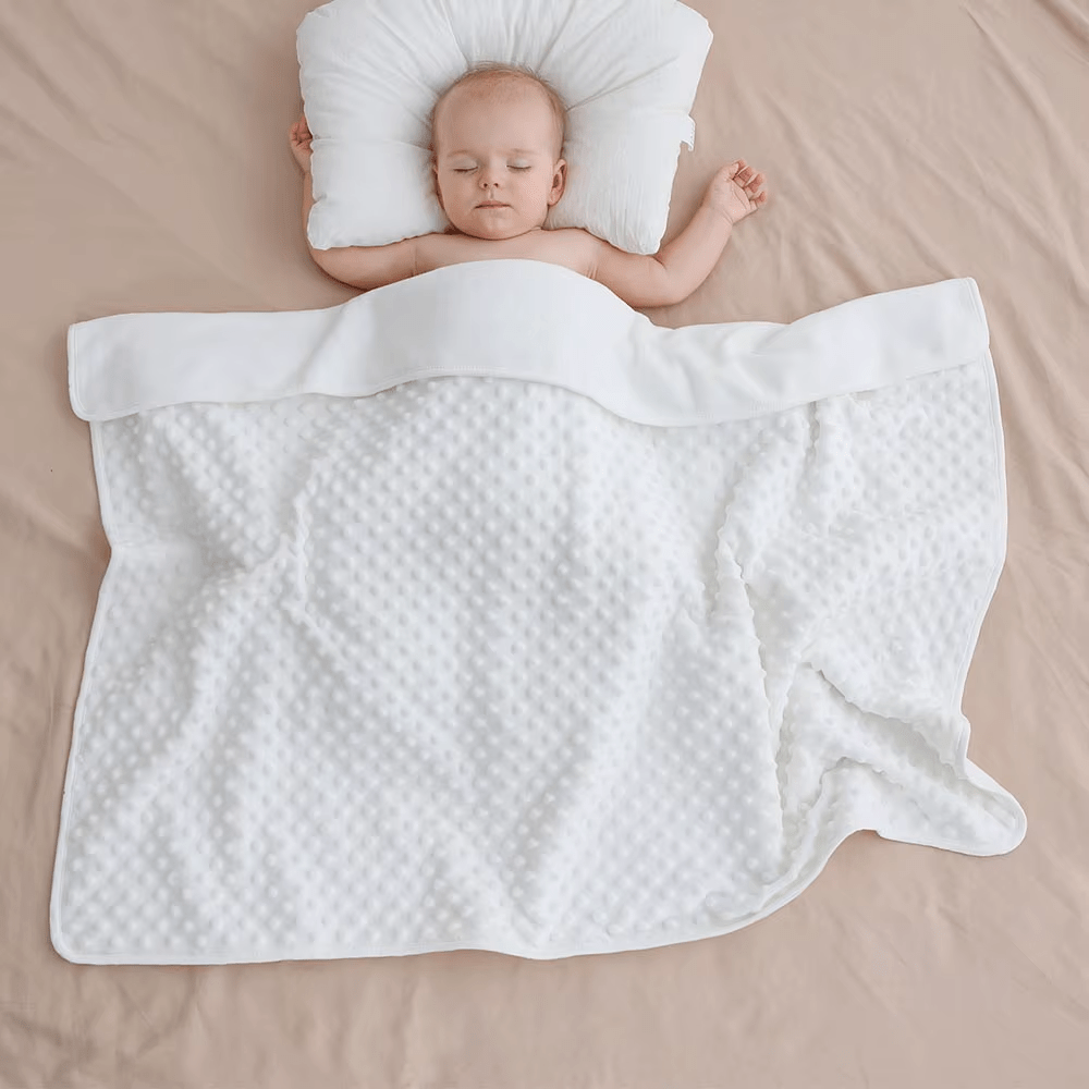 Petite fille souriante enveloppée dans une couverture bébé rose douce