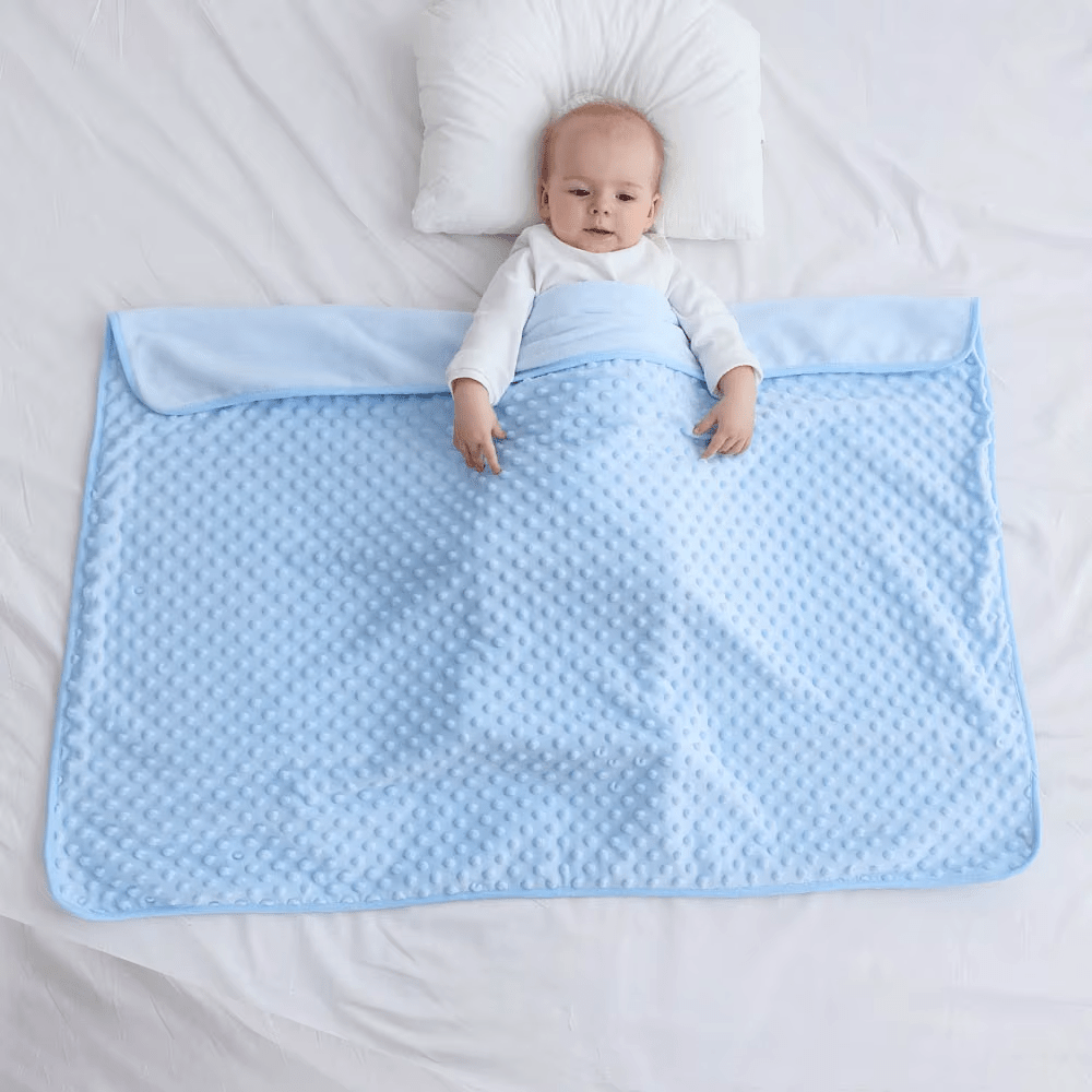 Bébé allongé sur une couverture bébé bleu douceur