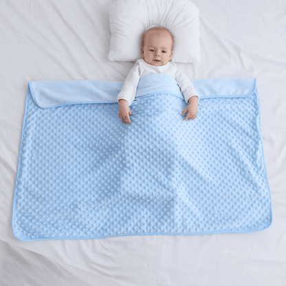 Bébé allongé sur une couverture bébé bleu douceur
