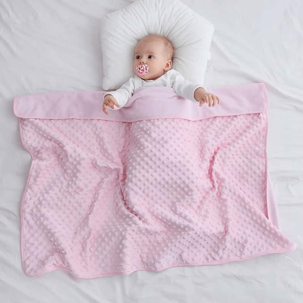 Bébé jouant avec une couverture bébé bleue douillette
