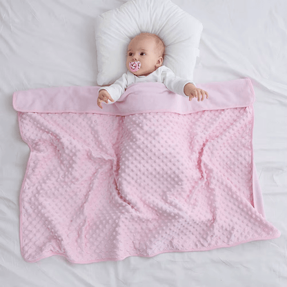 Bébé jouant avec une couverture bébé bleue douillette