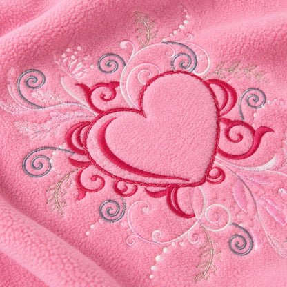 Gros plan sur le cœur brodé de la couverture chaude bébé rose
