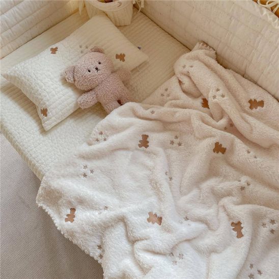 Couverture enfant en sherpa avec peluche ourson sur lit bebe