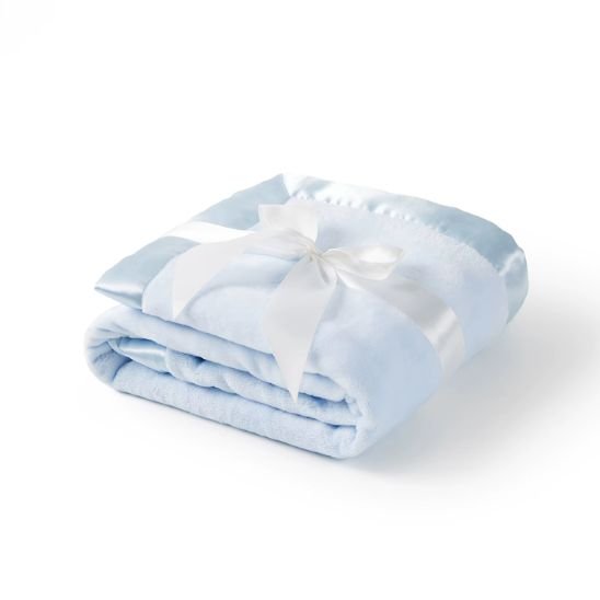 Couverture naissance bébé bleue pliée avec bordure en satin