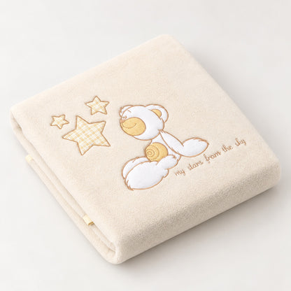 Couverture en polaire bébé coloris blanc écru avec ourson et étoiles brodées, pliée