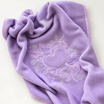 Couverture polaire bébé brodée violette drapée, détail de la broderie cœur et volutes