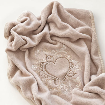 Couverture polaire bébé brodée taupe drapée, détail de la broderie cœur et volutes